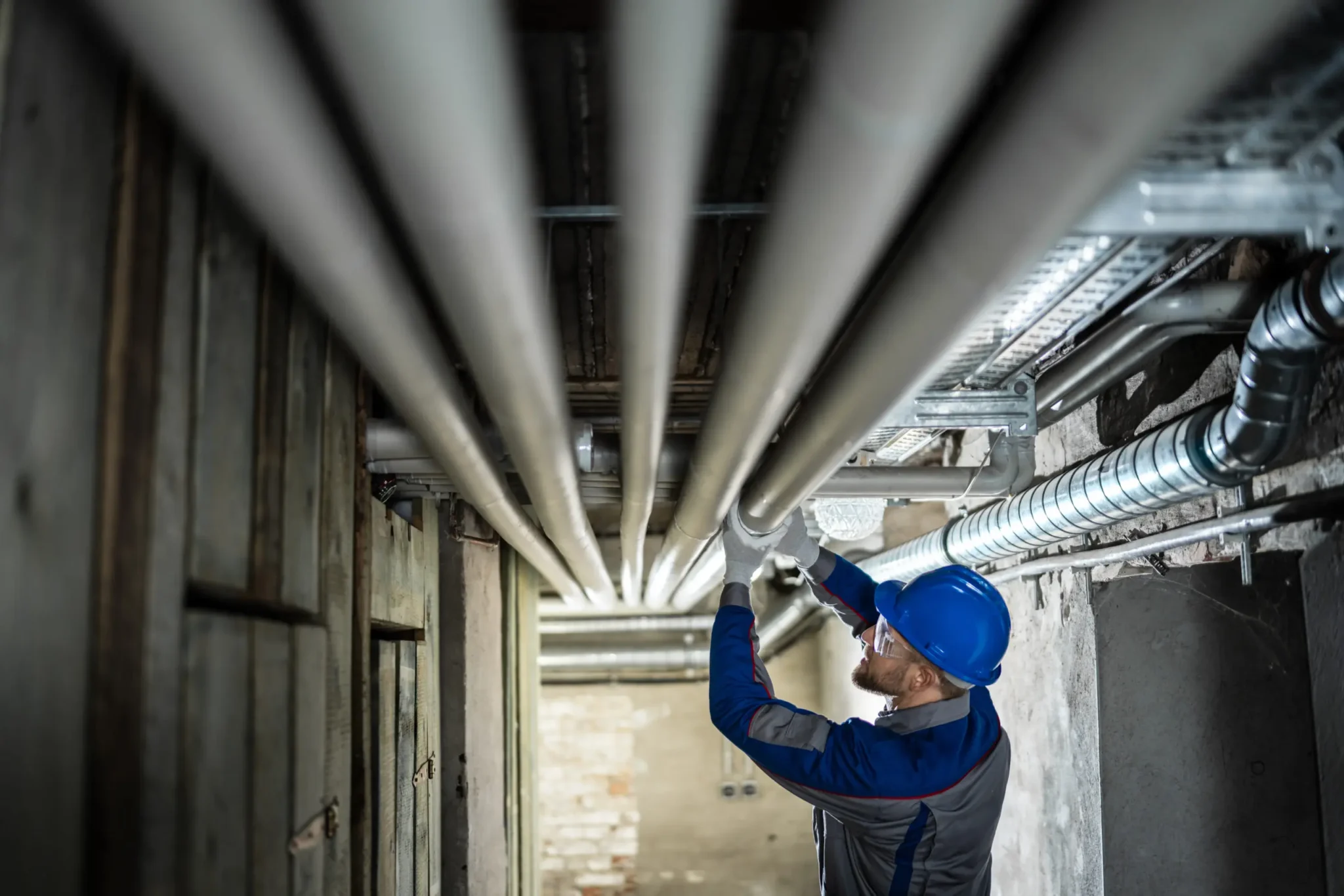 Close-up of a backwater valve being installed on a building drain below a basement floor