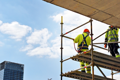 Plumber installing rough-in lines in an open commercial unit under construction