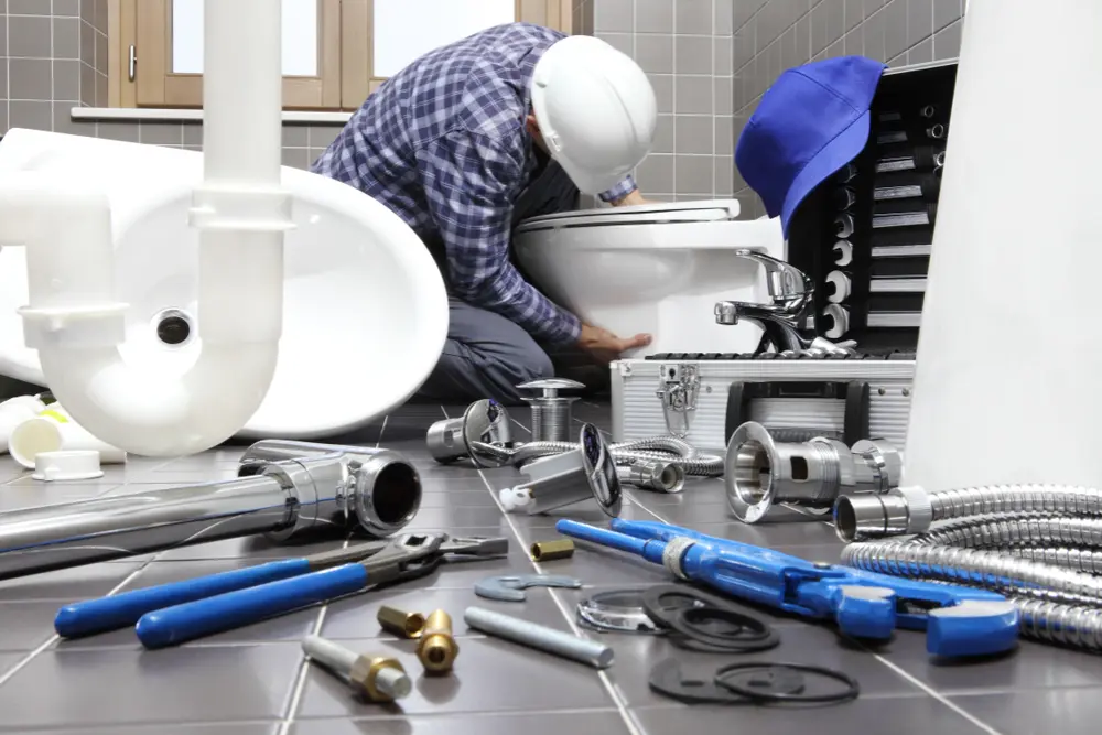 Poly-B Plumbing technician repairing a leaking bathroom faucet in a residential Ontario home