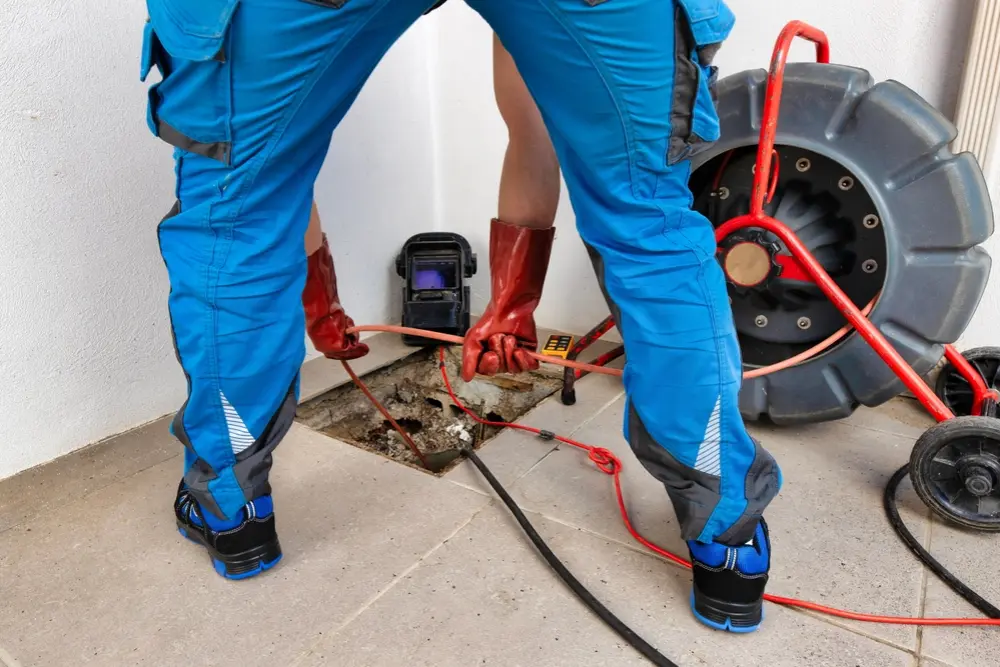 Plumber working under a kitchen sink in a North Bay home